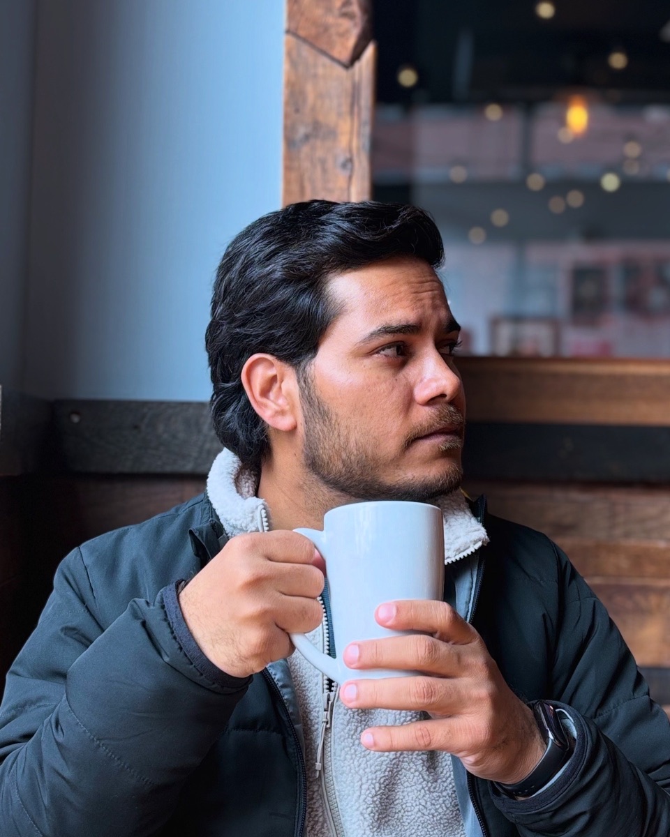 Avinash Holmes holding a cup of coffee